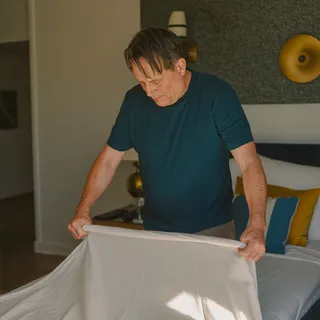A volunteer making a bed